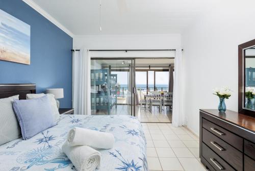 a bedroom with a bed and a view of the ocean at Eden Dunes 68 in Shelly Beach