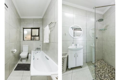 a white bathroom with a toilet and a sink at Eden Dunes 68 in Shelly Beach