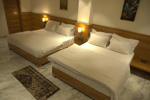 a hotel room with two beds and a rug at Hotel HS Inn Swiming Pool Room in Jaipur