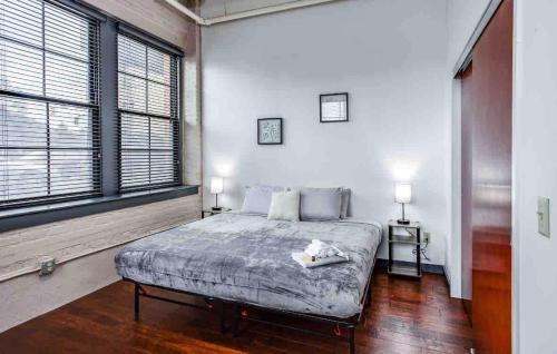 a bedroom with a bed and a large window at NY Style Loft with KingBed in Rochester