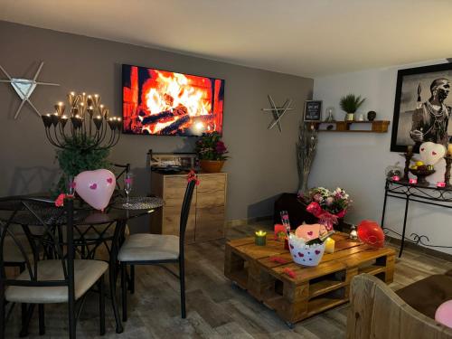 a living room with a table and a fireplace at Gîte chez carline classé meublés du tourisme 3 étoiles in Fultot