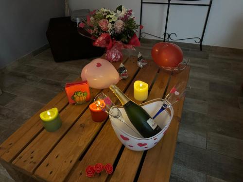 a table with a bottle of wine and candles on it at Gîte chez carline classé meublés du tourisme 3 étoiles in Fultot