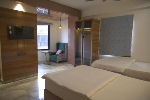 a hotel room with two beds and a television at Hotel HS Inn Swiming Pool Room in Jaipur