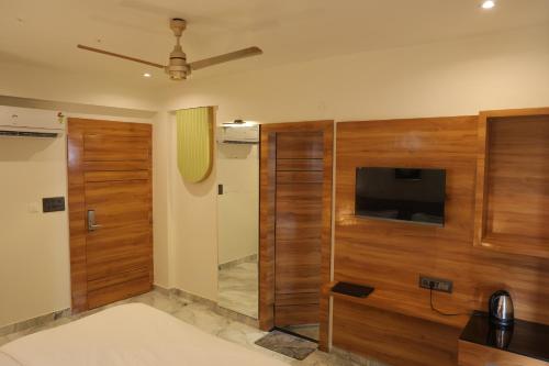 a room with a television and a sliding door at Hotel HS Inn Swiming Pool Room in Jaipur