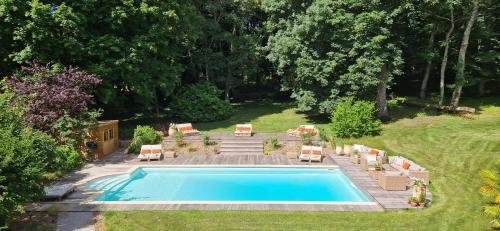 a swimming pool in a yard with lounge chairs at La Maison 1680 in Couches