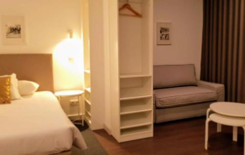a hotel room with a bed and a couch at CBA Suites Madeira in Funchal