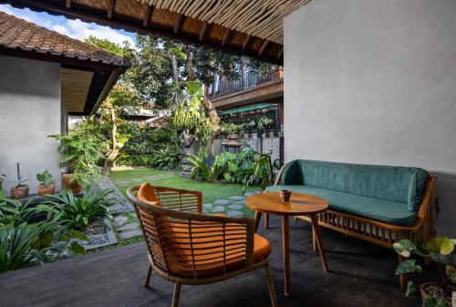 a patio with a couch and chairs and a table at Cloudspace Ubud in Ubud
