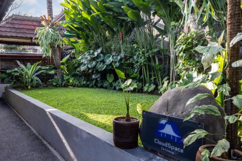 a garden with a recycle sign and a plant at Cloudspace Ubud in Ubud