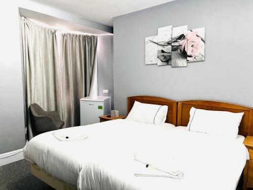 a bedroom with a white bed and a window at Regent Hotel in Eastbourne