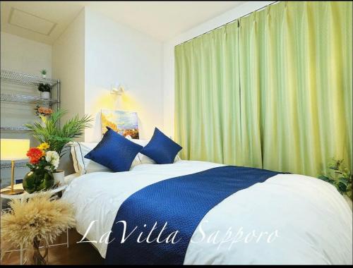 a bedroom with a bed with blue pillows at 札幌 LaVilla Sapporo 新築一軒家 in Minami-jūichijō