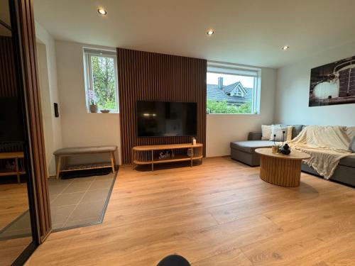 a living room with a couch and a flat screen tv at luxury Apartment by Skyactive in Tromsø