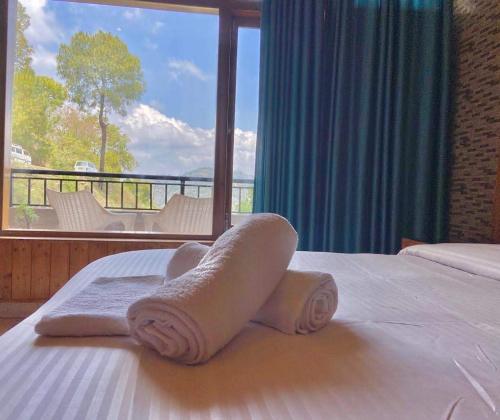 カソーリにあるThe Rustic villa kasauliのタオルが敷かれたベッドのあるホテルの部屋