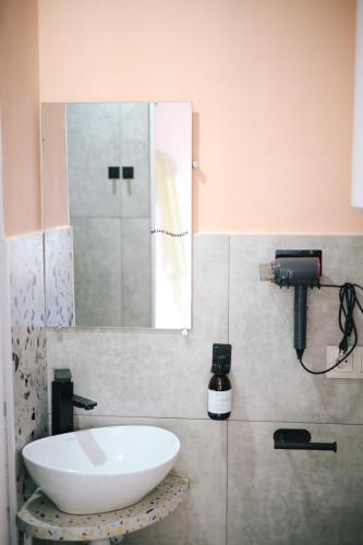 a bathroom with a white sink and a mirror at Buna Guest House in Gyumri