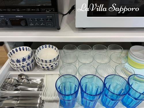 a drawer filled with glasses and plates and a microwave at 札幌 LaVilla Sapporo 新築一軒家 in Minami-jūichijō