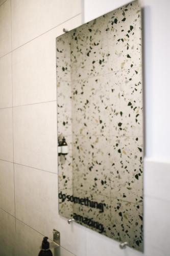 a mirror in a bathroom with a wall covered in confetti at Buna Guest House in Gyumri