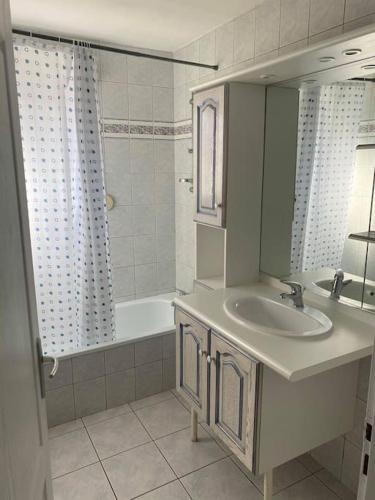 une salle de bain avec un lavabo, une baignoire et un miroir dans l'établissement La Magie entre deux lacs, à Gérardmer