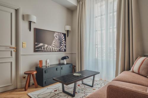 un salon avec un canapé et une table dans l'établissement Nestay Sentier, à Paris