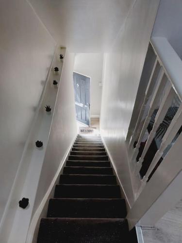a staircase in a building with a black stair case at Seaside Apartment in Moreton