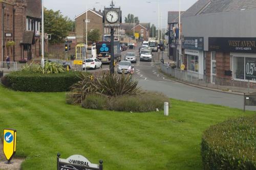 a clock tower on a street in a town at Seaside Apartment in Moreton