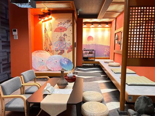 a room with tables and chairs and a wall with umbrellas at 楽心居 in Osaka