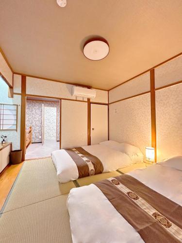 a bedroom with two beds and a window at 楽心居 in Osaka