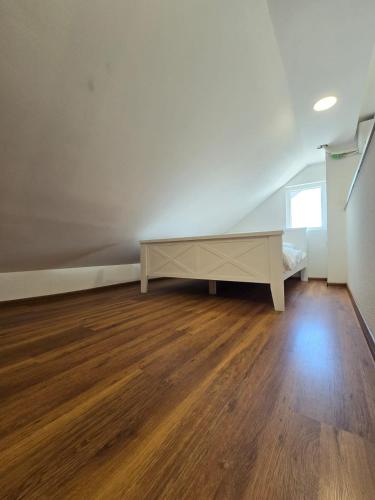 an empty room with a bed and wooden floors at Hotel Mažijanik in Nikšić