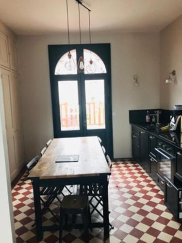 - une cuisine avec une table et un sol en damier dans l'établissement La petite Jacqueline, Maison classée 3 étoiles, hyper centre face plage, à Houlgate