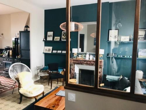 un salon avec une cheminée et un miroir dans l'établissement La petite Jacqueline, Maison classée 3 étoiles, hyper centre face plage, à Houlgate