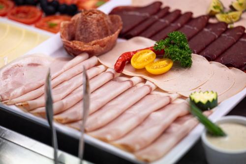 a tray of hot dogs and other meats on a table at B&B Hotel Sonneck in Naz-Sciaves