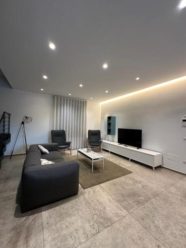 a living room with a couch and a flat screen tv at Il Cavaliere Bed and Breakfast in Caserta