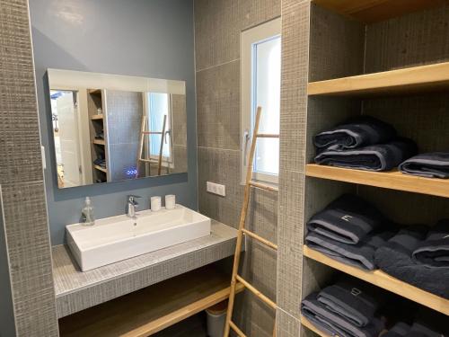 a bathroom with a sink and a mirror and towels at Villa Arbevhio in Bonifacio