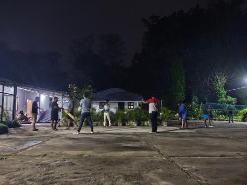 a group of people playing a game of baseball at night at Lara Homestay in Gonebidu