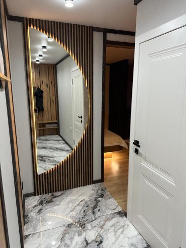 a bathroom with a large mirror in a room at Лободы 33 in Karagandy