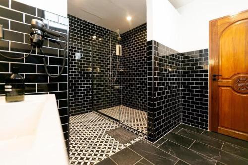 a black tiled bathroom with a shower with black tiles at Penthouse Lamoon in Bangkok