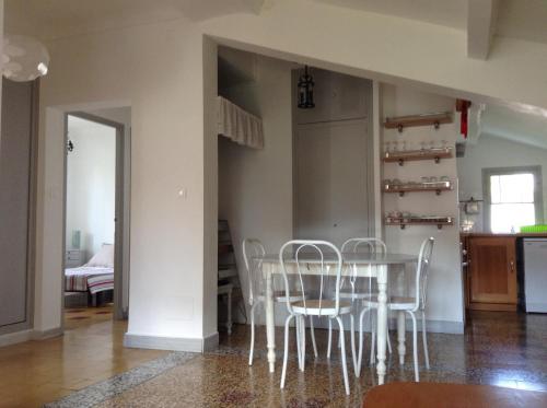 une salle à manger avec une table et des chaises blanches dans l'établissement Venise Languedocienne, à Sète