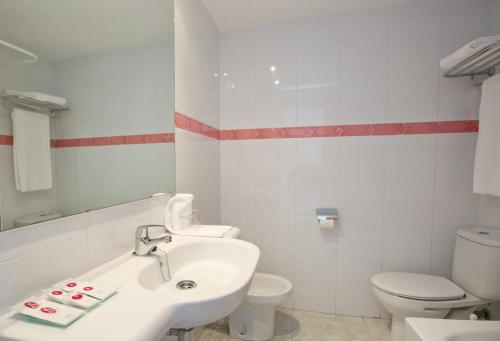 a white bathroom with a sink and a toilet at JS Miramar in Can Picafort