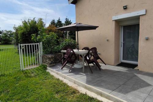 une table et des chaises avec un parasol sur une terrasse dans l'établissement Studio paisible, à Saint-Cyprien