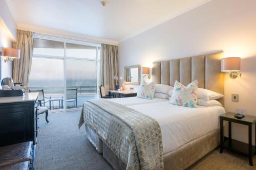 a hotel room with a large bed and a large window at Beverly Hills in Durban