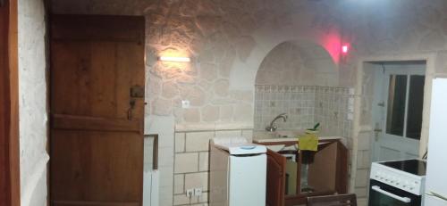a small kitchen with a sink and a door at La maison paisible au village in Channay-sur-Lathan