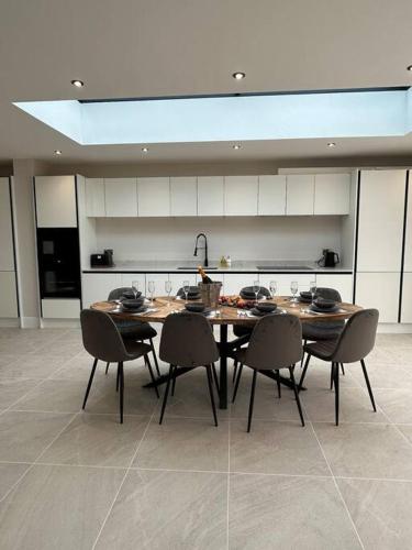 a dining room with a table and chairs in a kitchen at York Fields Retreat - 4 Ensuite Bedrooms in York