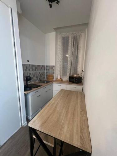 - une cuisine avec une table en bois dans une chambre dans l'établissement Appartement côté centre-ville, à Marseille