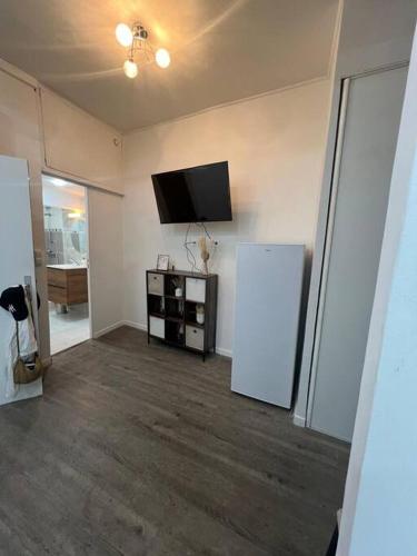 Il comprend un salon avec un réfrigérateur et une télévision à écran plat. dans l'établissement Appartement côté centre-ville, à Marseille