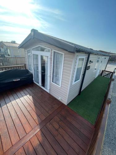 a large wooden deck with a house at Lake District Stunning Lodge in Plumbland