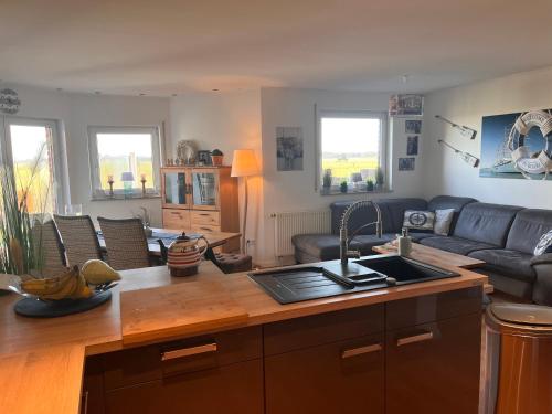 a kitchen and living room with a sink and a couch at Haus am Meer in Dorum Neufeld