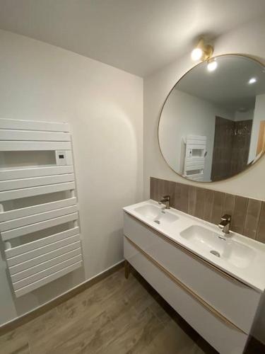 une salle de bain avec un lavabo et un miroir dans l'établissement Maison de Campagne avec Piscine, à Magescq