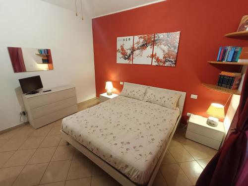 a bedroom with a bed and a red wall at House 39 in Capranica