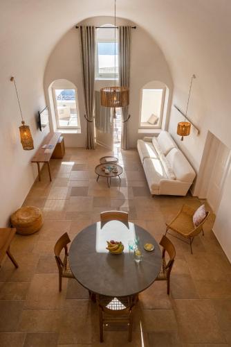 a living room with a table and a couch at La Maltese Estate in Imerovigli