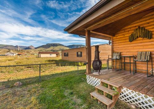 a wooden porch on a cabin with mountains in the background at Warrick Cabin in Creede