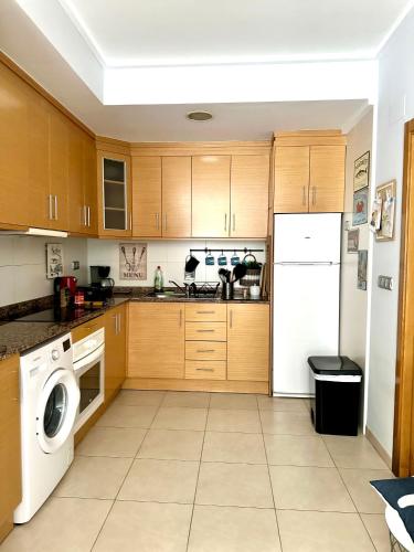 a kitchen with wooden cabinets and a white refrigerator at Alicante Hills in Alicante