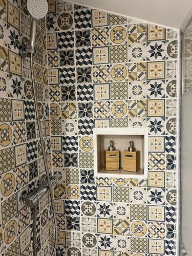 La salle de bains est pourvue d'un mur en carrelage et d'une douche. dans l'établissement AbriZen Toulouse Hypercentre, à Toulouse